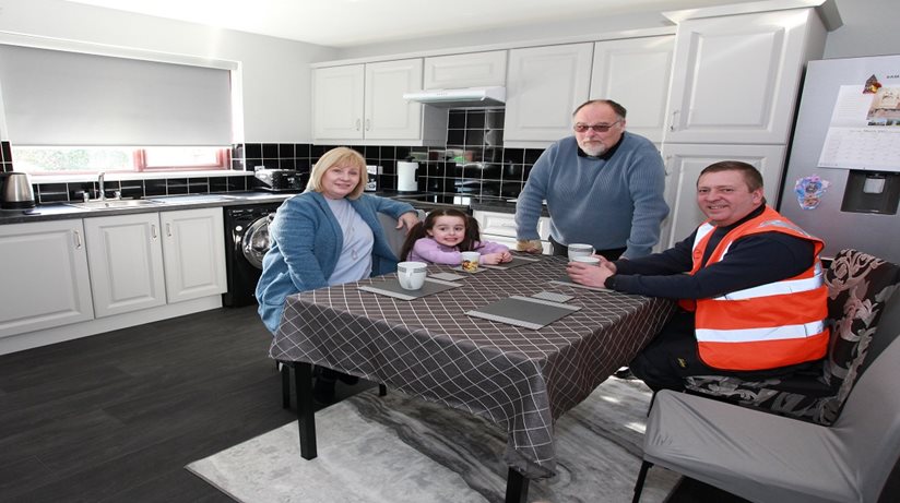 Patrick Cochrane and his granddaughter Holly enjoy a cuppa in their new kitchen along with Housing Executive patch worker Carole Toner and James Johnston, from Engie. Homes across Co Down are benefiting from a major £700,000 upgrade investment.   
