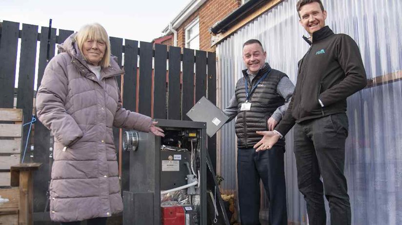 Jane Mackay, from Moygashel Park, Dungannon, admires her new boiler along with Housing Executive patch manager Peter McVey (centre) and Sean McBride, H&A Mechanical Services
