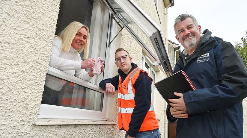 Ards tenant Linda McIlroy is delighted with her new windows which she shows off to Scott Stewart, Engie, and Ivor Gibson (right) from the Housing Executive.