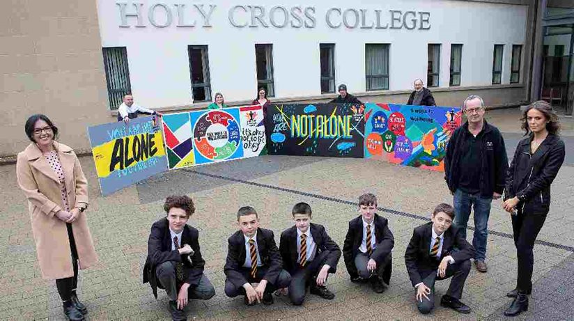 The mental health murals created by pupils at Holy Cross College, before they were mounted across Strabane.  Back row L-R: Dominic Bonner, Youth Action NI, Jeanette McCrory, Head of Art, Marie Forbes, art teacher, William McAteer and Ivan Barr, Melmount Community Forum.  Front row L-R: Rebecca Logue, NIHE patch manager, Holy Cross College pupils Joshua Kingh, Corin Kelly-Herron, Colt McCay, Jake McAnenny, Caleb Kingh, NIHE’s Eddie Breslin, Good Relations Officer and Rachael Leitch, patch manager