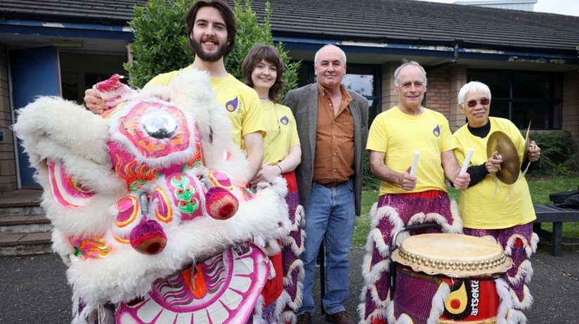 Dr Sean Brennan, Good Relations Officer, Housing Executive, with the Chinese lion and some of the performers at the festival at Wolfhill Centre.