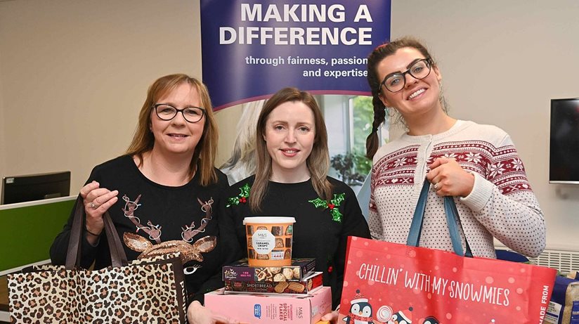 Staff members at a coffee morning at the Housing Centre in Belfast check out the non-perishable food which were donated to help support vulnerable households.