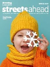 A child holds a paper snowflake. Streets Ahead 2020.