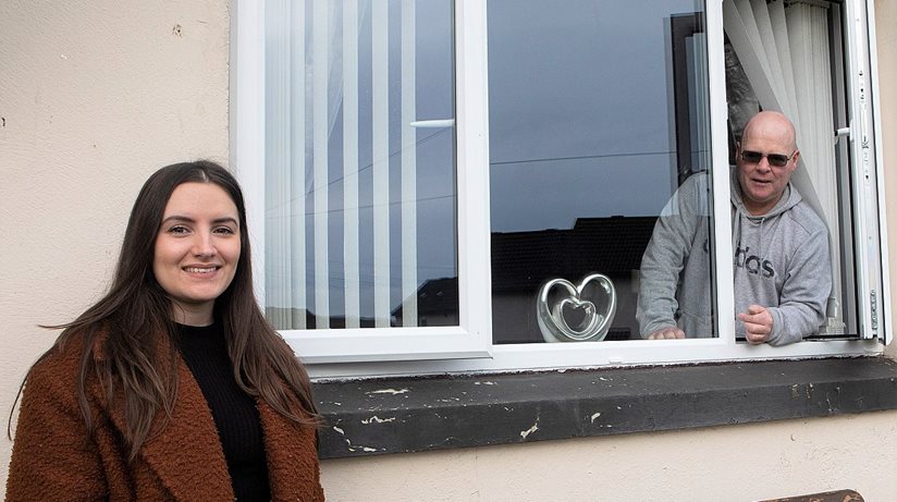 Housing Executive patch manager Nicole Nicell with tenant Anthony Canning beside one of the new windows fitted at his home in Rinmore Drive, Creggan Estate.