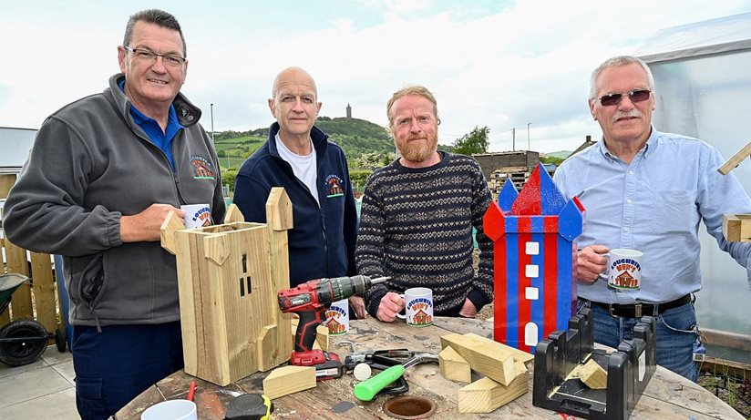 Men’s Shedders Mark Anderson, Stephen Rodgers and Joe Tate take a tea break while building bird boxes with Gus Moore (third from left), from the Housing Executive.