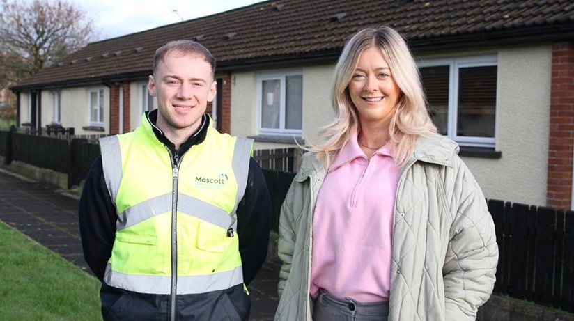 Housing Executive Patch Manager, Meabh Beatty pictures with Sean Watters from M&M Contractors in front of homes fitted with new PVC double-glazed windows. 