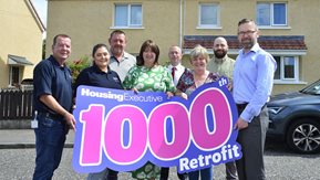 Group pose with "1000th Retrofit" banner