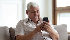 A man sitting, browsing on his phone.