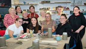 A group of women making crafts with clay. 