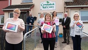 Seven people pose outside community centre