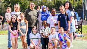Children and adults smile for a photograph