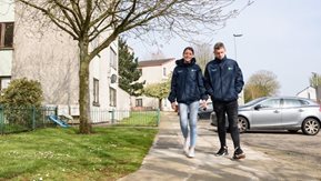 A man and woman walking on the footpath.