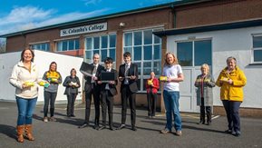 5 people pose with Sustainable Rural Communities placards