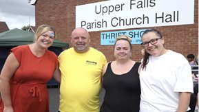 A group of people stand outside of the Lower Falls Parish Hall 