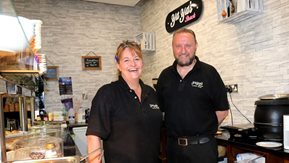 A man and woman working in a café.