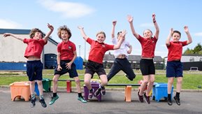 A group of school children leap into the air.