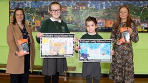 Two pupils pose with their pictures