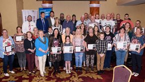 A large group of people pose with their certificates.