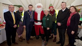 Santa and his elves with a group of other people.