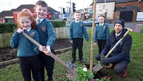 Rebecca, Alexander, and Carly, with John Ingram – two of the children hold a spade with a bedding plant.