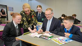 A man and woman with three school pupils.