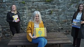 Three women pose with gifts