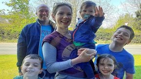 A woman and man pose with their children