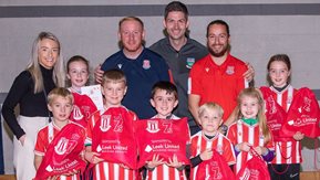 Children and coaches pose with prizes