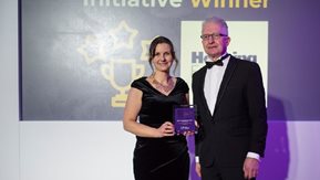 A woman and man in evening wear at an awards ceremony