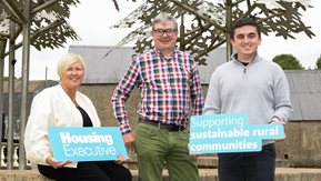A group of people standing holding saying Northern Ireland Housing Executive