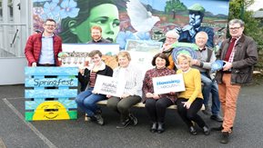A group of people posing in front of a mural for the rural community awards
