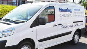 A white van with Housing Executive branding.