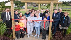 A group of adults and children open a new community garden.