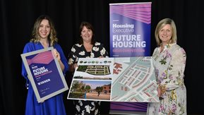 Three women with Future Housing artwork