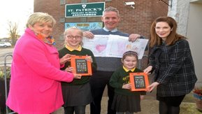 Two school children with their prizes and artwork.