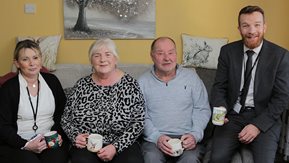 Four people relax on a couch.