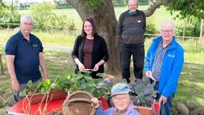 Several people pose in a rural setting.