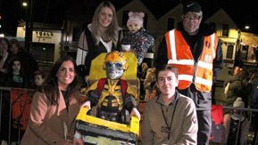 A group of people with children in costumes at the halloween event.