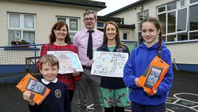 Several adults with two school children and their prizes and artworks.