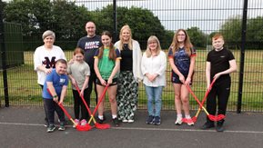 A group of adults and children show off some of the new sports equipment.