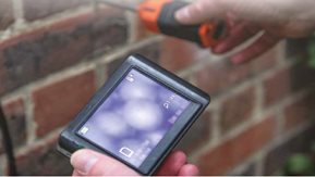 A workman carries out an external inspection of a property.