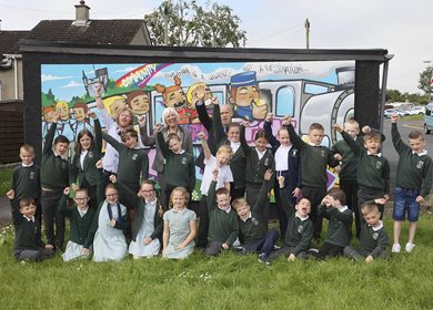 Gus Moore and Owen Brady pose by the mural with Kilcooley Primary School Principal, Pauline Brown and pupils